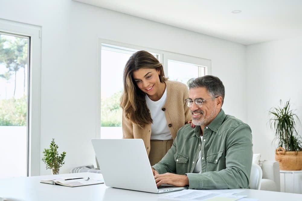 A couple reviewing their healthcare options together on a laptop at home