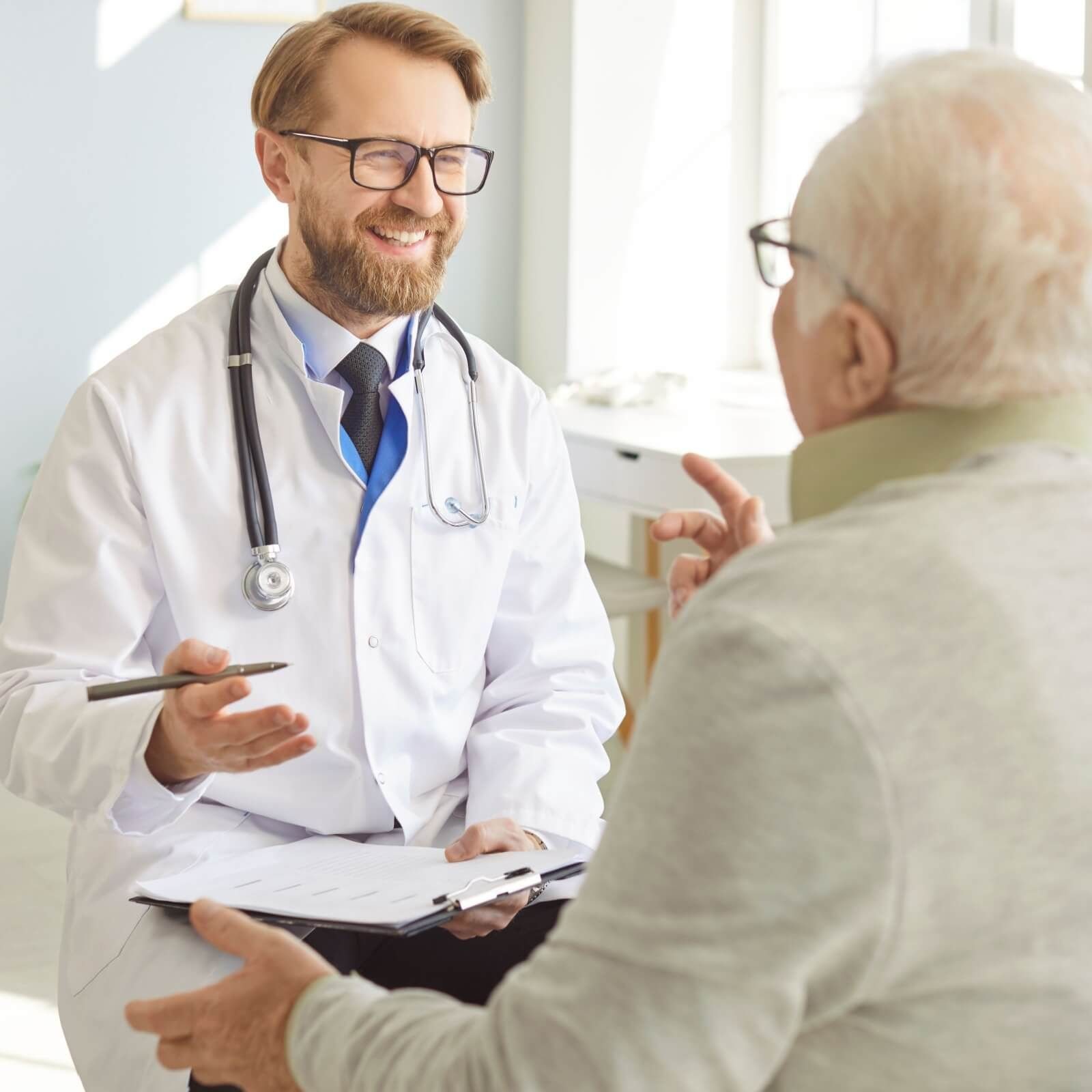 Physician with a stethoscope talking with an older patient during a consultation