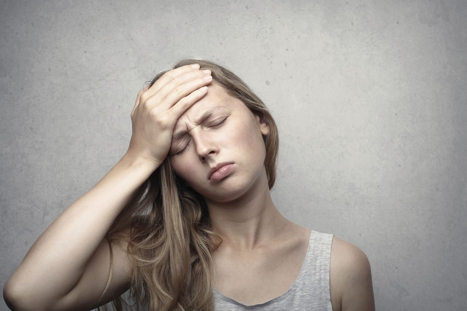 Woman pressing her hand to her forehead with a headache