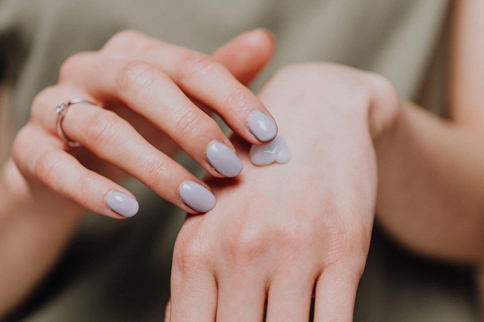 Person rubbing moisturizing cream into the back of her hand